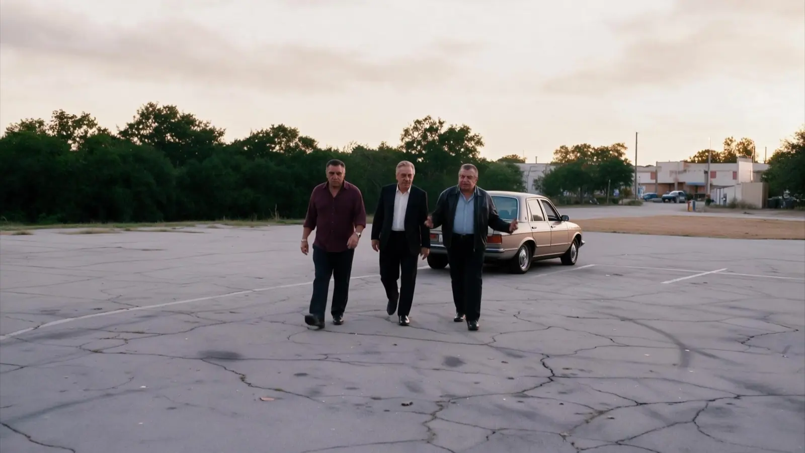 Tony, Sal and Vinny walking across an empty parking lot at sunset